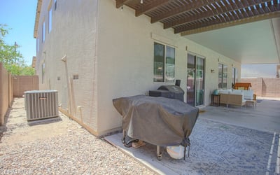 Covered patio with built-in grilling area, spacious seating, and convenient access to the backyard pool. A functional outdoor living area designed for entertaining in Waddell.