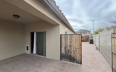 Covered patio opens to an extended paved side yard leading directly to the RV gate, providing excellent accessibility, additional storage options, and low-maintenance outdoor living.