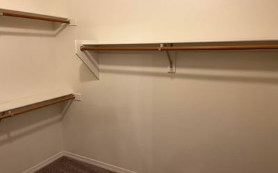 This oversized walk-in closet provides extensive hanging space and organized storage, making it easy to keep wardrobes and personal belongings neatly arranged.