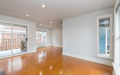 Spacious open-concept living area with natural light and access to a private outdoor balcony.
