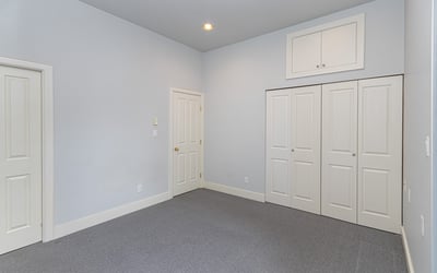 Spacious room with ample natural light, featuring dual closets and a versatile layout for various uses.