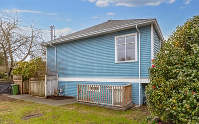 This well-maintained blue home features a spacious backyard, perfect for outdoor activities and gardening.
