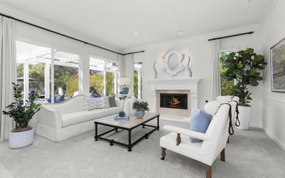 inviting living room featuring a cozy fireplace and large windows for abundant natural light.