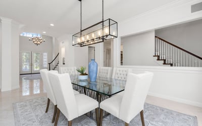 Bright and airy dining area, featuring a modern glass table and plush seating, perfect for gatherings.