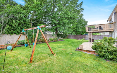 Spacious yard with swing set charm.