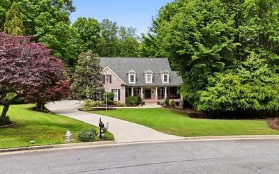 Beautifully landscaped home nestled on a quiet cul-de-sac, surrounded by mature trees and vibrant foliage.