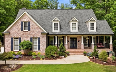 Beautifully landscaped, this spacious brick home features a welcoming porch and ample outdoor space for gatherings.