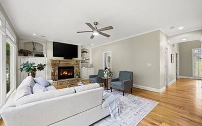 Spacious living area featuring a cozy fireplace, large windows, and modern finishes, ideal for gathering.