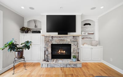 Cozy living space featuring a stone fireplace and built-in shelving, perfect for relaxation and entertainment.