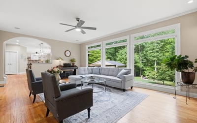 Spacious living room with expansive windows offering ample natural light and a picturesque view of the backyard.