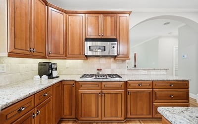 Experience this inviting kitchen, featuring rich wood cabinetry, granite counters, and modern stainless steel appliances.