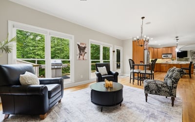 Spacious living area features large windows, modern kitchen amenities, and outdoor access for entertaining.