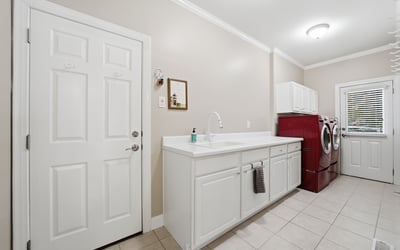 Spacious laundry room featuring ample counter space and modern appliances for efficient household tasks.