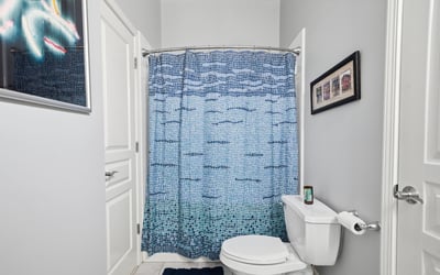 Bright and inviting bathroom featuring a colorful shower curtain and modern fixtures, perfect for daily use.