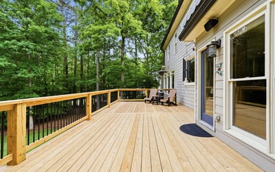 Spacious deck surrounded by lush greenery, perfect for outdoor gatherings and enjoying nature.