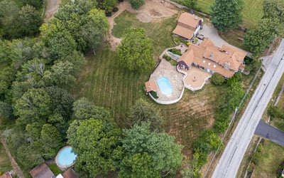 Sprawling property with two pools, vibrant greenery, and ample space for outdoor activities and relaxation.