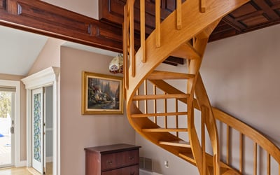 Discover a unique spiral staircase that enhances the inviting entryway of this modern home.