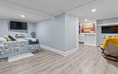 Spacious basement retreat featuring dual TVs, ample storage, and a cozy atmosphere for relaxation.