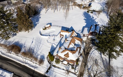 Spacious property with picturesque winter scenery, featuring a unique layout and ample outdoor space for recreation.