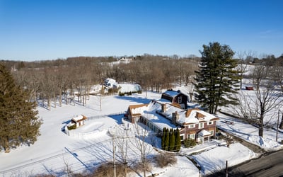 Spacious country property with expansive snow-covered grounds and classic architecture, perfect for year-round living.