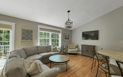 Bright and inviting living area features large windows, cozy seating, and a seamless flow to outdoor space.