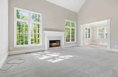 Bright, airy living space featuring large windows, a cozy fireplace, and abundant natural light.