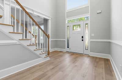 Bright and airy entryway featuring natural light, modern finishes, and an inviting two-story ceiling.