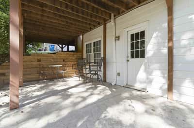 Spacious covered patio with built-in seating, perfect for outdoor gatherings and relaxation and exterior entrance to basement.