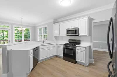Modern kitchen featuring ample counter space, stainless steel appliances, and abundant natural light throughout.