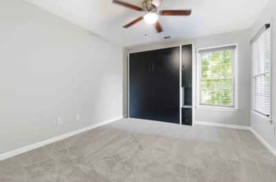 Bright and versatile room featuring a wall-mounted murphy bed, perfect for maximizing space and comfort.