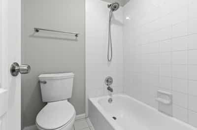 Full guest bathroom with double sinks, separate bathtub and water closet