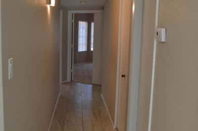 Freshly updated hallway with modern tile flooring, neutral finishes, and contemporary lighting leading to the home's bedrooms and bathrooms. Every detail reflects the quality renovations throughout this Phoenix property.