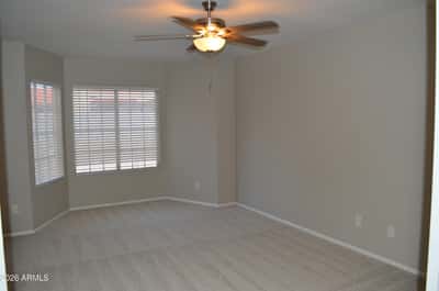 Spacious primary bedroom featuring multiple windows, fresh carpeting, ceiling fan, and a calming neutral color palette. A comfortable retreat designed for relaxation and everyday comfort.