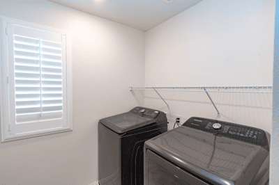Bright laundry room featuring modern appliances and ample space for organization and utility.