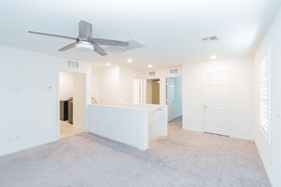 Bright, open living space with a modern ceiling fan, featuring versatile layouts and updated finishes throughout.