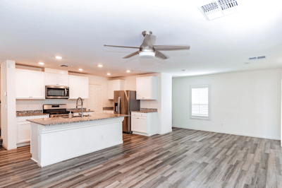 Modern kitchen with stainless steel appliances opens to a spacious living area, perfect for gatherings.