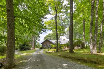 Nestled among lush trees, this spacious home offers a peaceful retreat with abundant outdoor space.