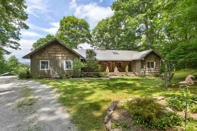 Spacious, wood-clad home surrounded by lush greenery, offering a tranquil retreat with scenic views.