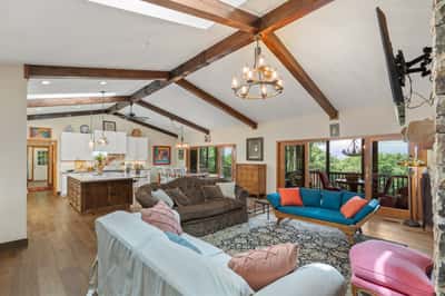 Spacious open-plan living area featuring vaulted ceilings, modern kitchen, and gorgeous mountain views from the balcony.
