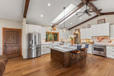 Modern kitchen with ample natural light, featuring a spacious island and sleek appliances for culinary enthusiasts.