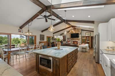 Bright and spacious kitchen featuring a large island, vaulted ceilings, and seamless outdoor access.
