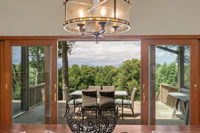Experience seamless indoor-outdoor living with stunning views of lush greenery from this inviting dining area.