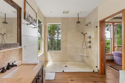 Spacious bathroom featuring a large walk-in shower and ample natural light, perfect for relaxation.
