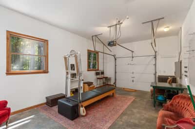 Spacious garage featuring workout equipment, natural light, and ample storage for your recreational needs.