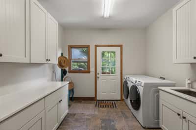 Bright and functional laundry room featuring ample cabinetry and convenient outdoor access. Ideal for everyday tasks.