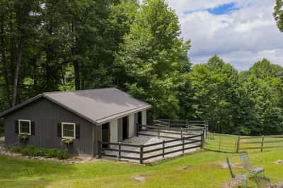This rustic property features a spacious barn, surrounded by lush greenery and scenic landscapes.