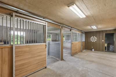 Spacious horse barn featuring multiple stalls and ample storage, ideal for equine enthusiasts and agricultural endeavors.