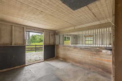 Spacious indoor area with large access doors, perfect for a variety of uses or livestock housing.