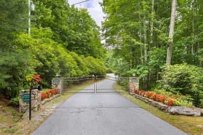 Private gated entrance leads to a lush, wooded retreat, perfect for your dream home or getaway.