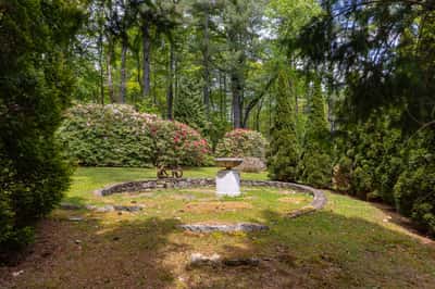 Discover a private backyard oasis surrounded by lush greenery and vibrant floral displays, perfect for relaxation.